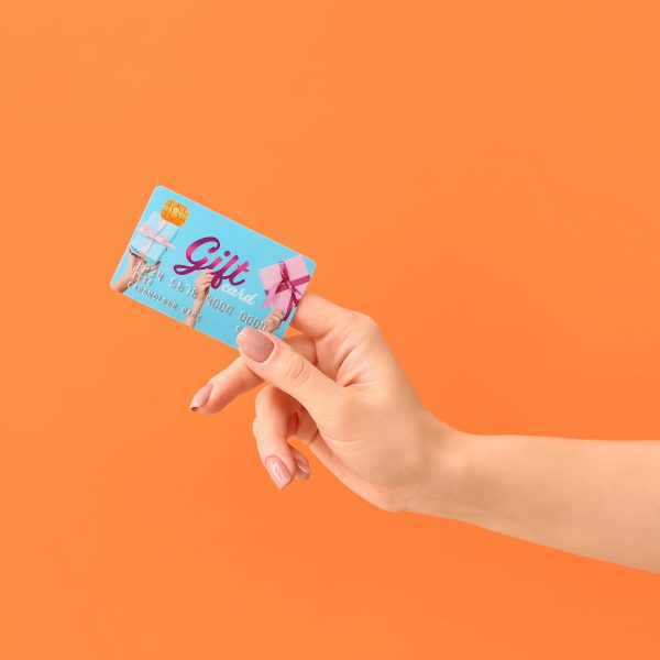 A hand holding a blue card with "Gift" on it on an orange background.